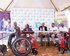 a group of people sitting in a tent with wheelchairs in front of them | © Reach a Hand Uganda